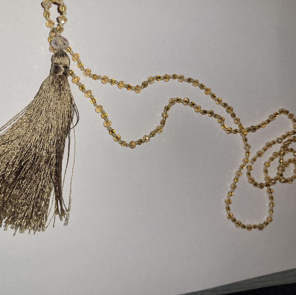 Necklace with gold tassel and gold plastic beads